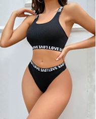 Siyah çapraz sırt ve Love lastikli sütyen külot takımı. S/M beden, esnek kumaş, gizli paketleme ve %100 yerli üretim. Modern ve